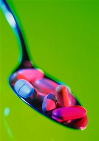 Image shows a teaspoon filled with pills and tablets