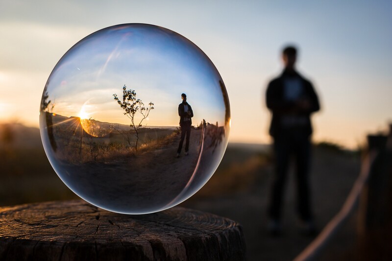 Reflective orb of a man standing in nature