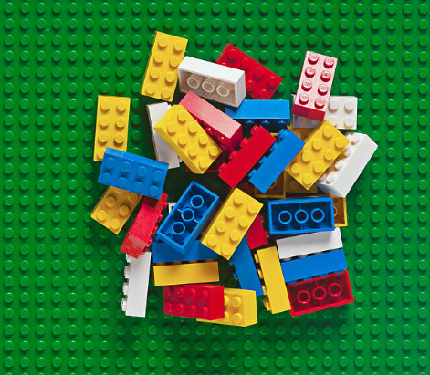 Pile of Legos on a green Lego mat.