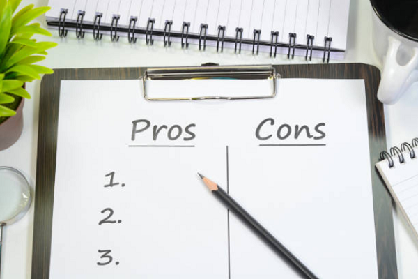 Clipboard holding a sheet of paper with columns for "Pros" and "Cons"