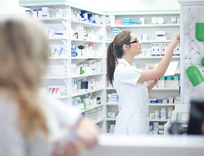 Pharmacy employee searching shelves in a community pharmacy
