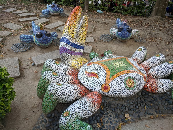 Rainbow crab and blue tadpoles with legs mosaic sculpture
