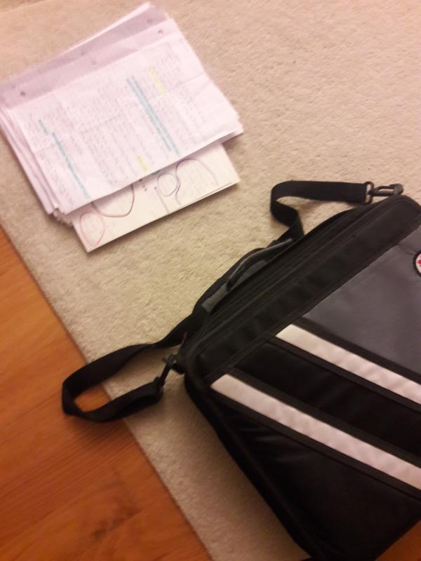 Giant stack of papers on carpet alongside a giant binder