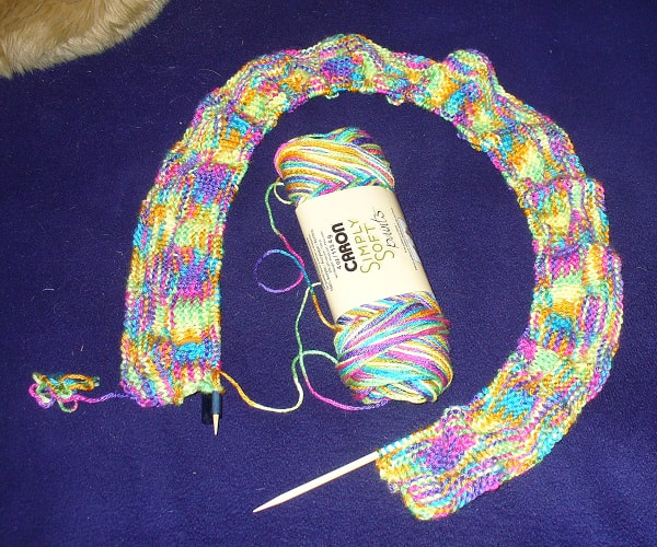 Rainbow yarn being knitted into a scarf