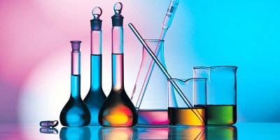 Beakers, flasks, and other lab equipment with liquid chemicals in them