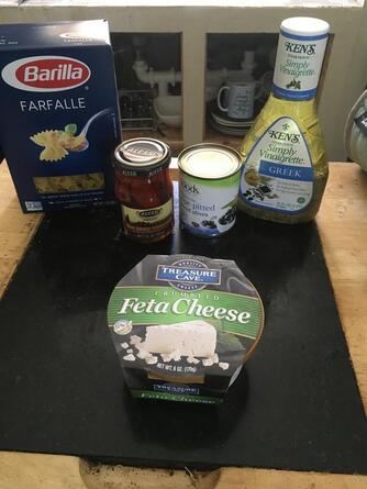 Ingredients for Greek Pasta Salad: Box of farfalle pasta, jar of sun dried tomatoes, can of sliced black olives, package of feta cheese, Greek dressing